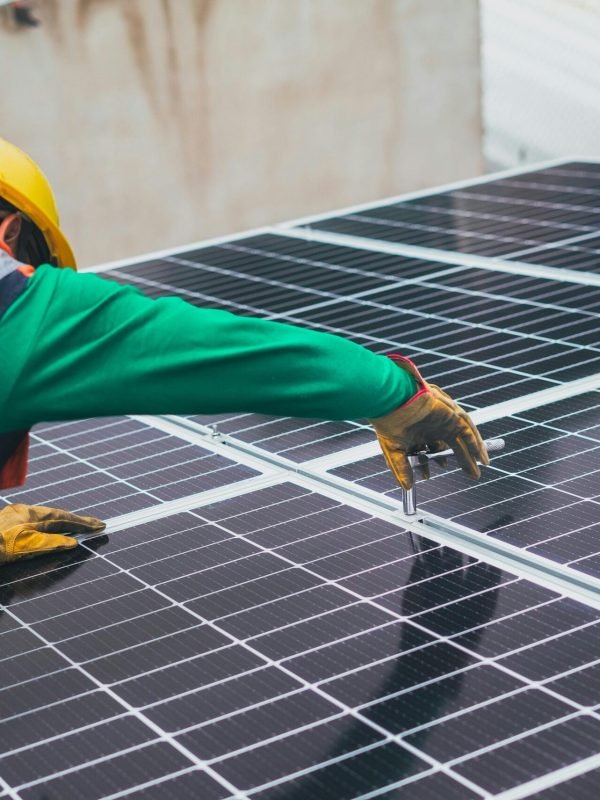 Technician installing solar panels on a rooftop for sustainable energy solutions.